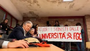 Persone in un'aula universitaria con uno striscione di protesta tenuto da un gruppo di giovani