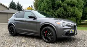 Alfa Romeo Stelvio Quadrifoglio grigia parcheggiata su un vialetto ghiaioso
