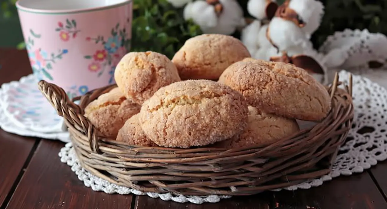 Cestino di biscottoni da inzuppo senza burro su tavolo in legno con tazza rosa