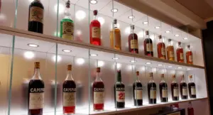 Bottiglie di alcolici esposte su scaffali illuminati, inclusi prodotti a marchio Campari