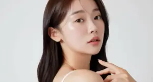 Donna con capelli lucenti e pelle luminosa su sfondo neutro