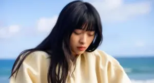 Persona con capelli lunghi e lucenti in riva al mare