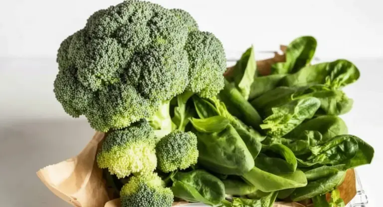 Broccolo e foglie di spinaci freschi su un tavolo