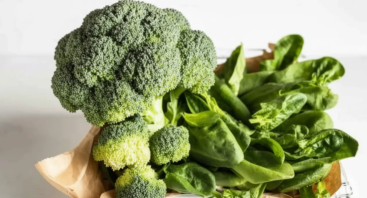 Broccolo e foglie di spinaci freschi su un tavolo