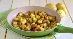 Patate alla carrettiera cotte in padella, su tovaglietta verde a quadretti
