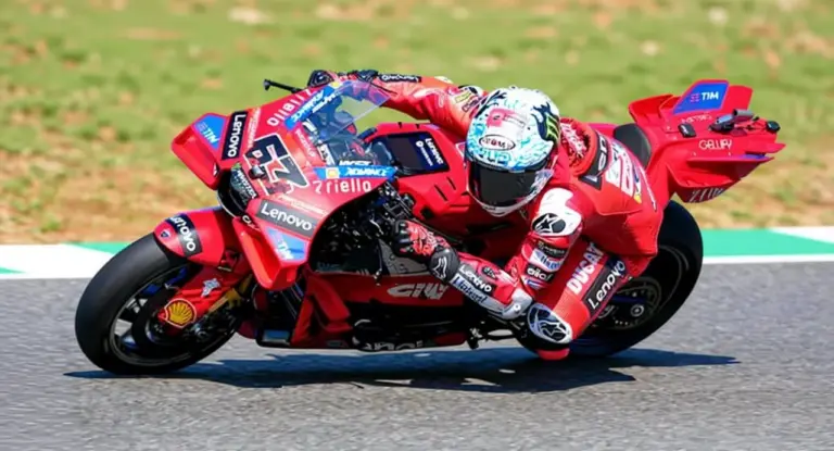 Pilota in piega su moto da corsa durante le prove del MotoGP su pista asfaltata