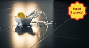 Ciotola con limone, spazzola e schiuma su pavimento scuro pulito